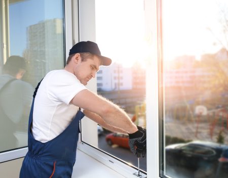 Construction worker repairing window in house Construction worker repairing window in house