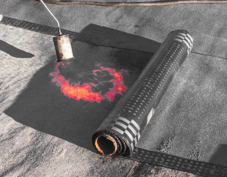 Roll roofing Installation with propane blowtorch during construc Roll roofing Installation with propane blowtorch during construction works