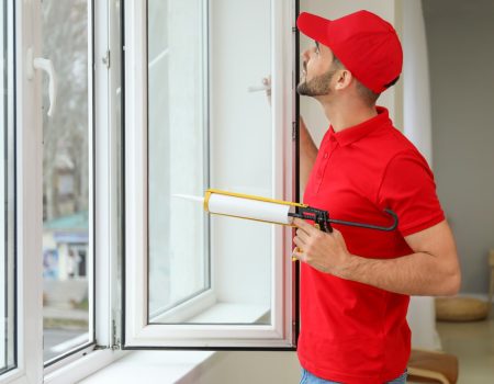 Young worker installing window in flat تركيب ابواب وشبابيك الوميتال